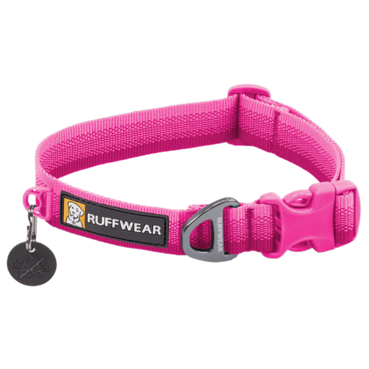 A bright pink Ruffwear dog collar with a silver metal D-ring and a black plastic buckle, featuring a black brand label with a dog logo and a small black hanging tag.