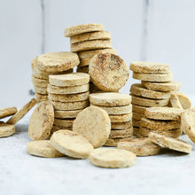 Load image into Gallery viewer, Stacks of round, brown cookies on a light gray surface with a neutral background